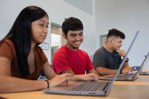 child smiling at laptop
